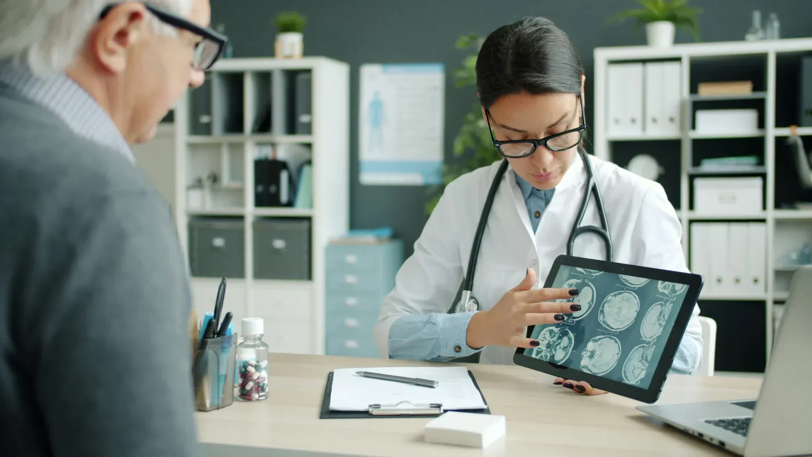 A doctor reviewing a scan on a tablet with a patient